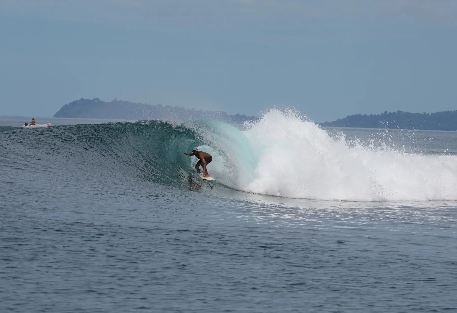 Surfeur dans un tube, au large d'une île tropicale